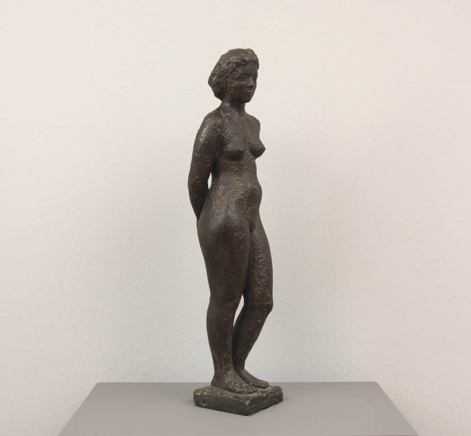 Bronzeplastik „Stehende Frau“ von Henry Luckow-Nielsen auf Sockel. Figurative Skulptur mit ruhiger Haltung und klassischer Formensprache in dunkel patinierter Bronze.