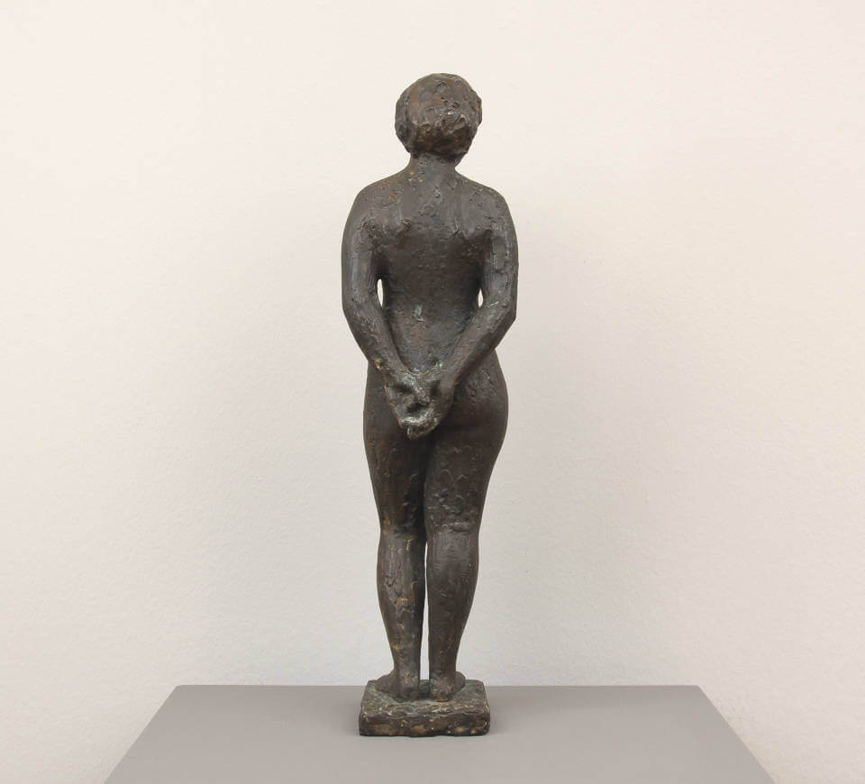 Rückansicht der Bronzeplastik „Stehende Frau“ von Henry Luckow-Nielsen auf Sockel. Figurative Skulptur mit ruhiger Haltung und klassischer Formensprache in dunkel patinierter Bronze.