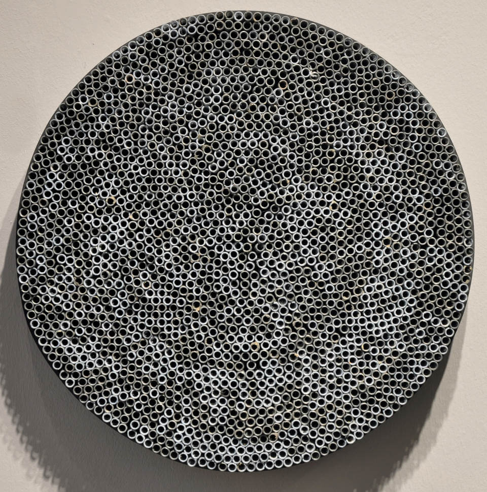 Runde Assemblage „Spiralen“ von Jens Chr. Jensen aus hunderten röhrenförmigen Eisenfedern. Die monochrome Wandarbeit erzeugt eine faszinierende geometrische Struktur und optische Tiefe