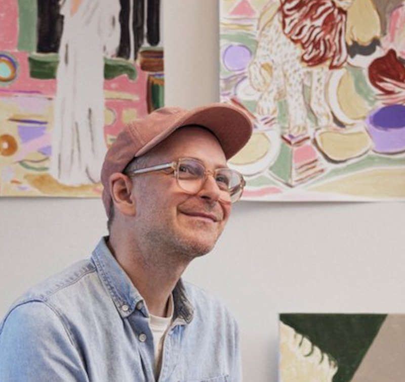 Atelieransicht mit sitzender Person - Mads Rafte Hein, farbenfrohen Gemälden, Interieur-Motiven, Pflanzen und Kunstwerken an der Wand