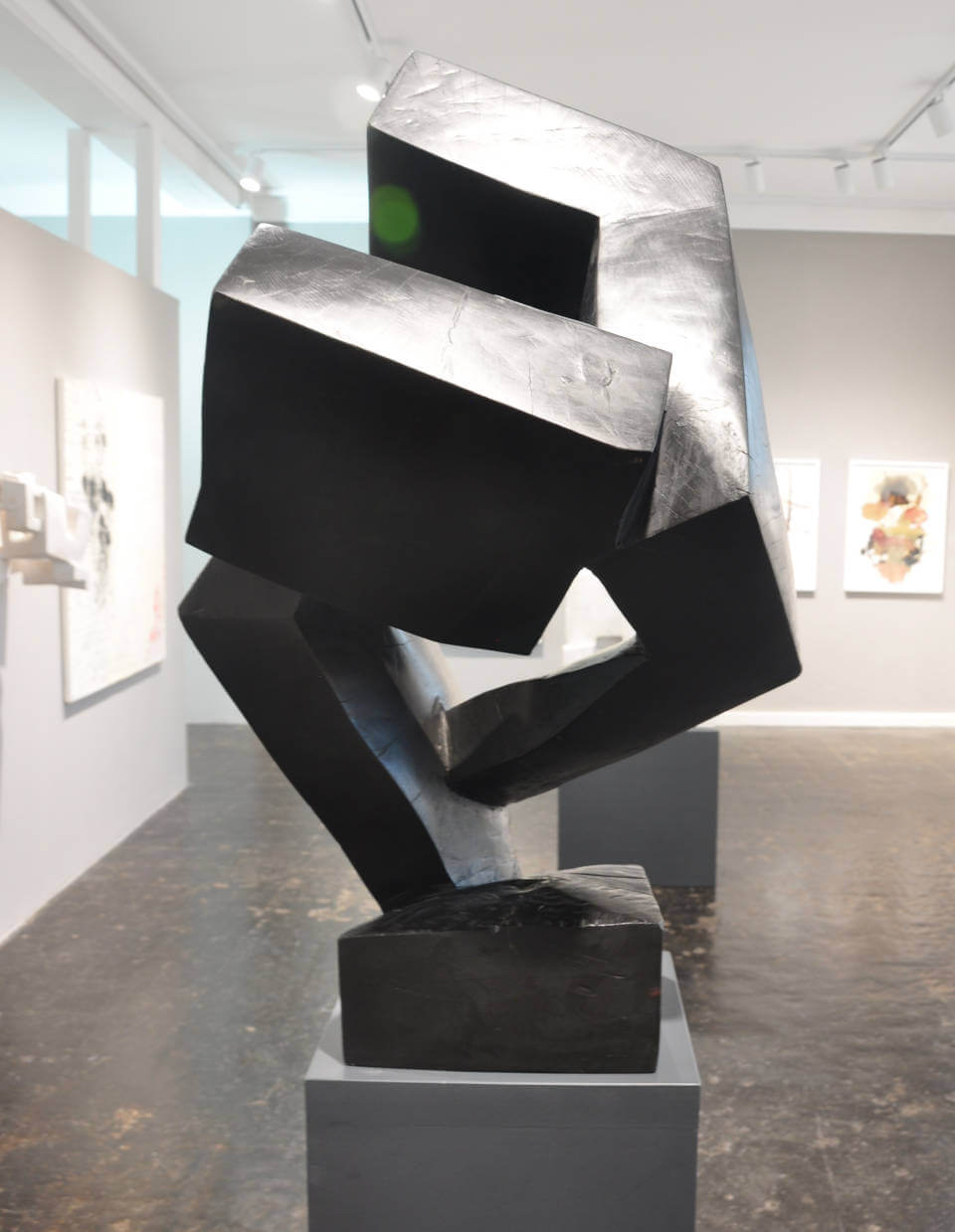 Abstrakte Skulptur „Falter“ von Mathias Kadolph aus dunkel patiniertem Material mit markanten geometrischen Formen und dynamischer Raumwirkung.