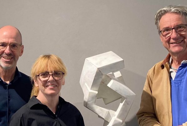 Steffi und Gordon Rieck mit Mathias Kadolph bei einem Künstlergespräch in der Galerie RIECK neben einer modernen abstrakten, weißgefassten Skulptur aus Holz