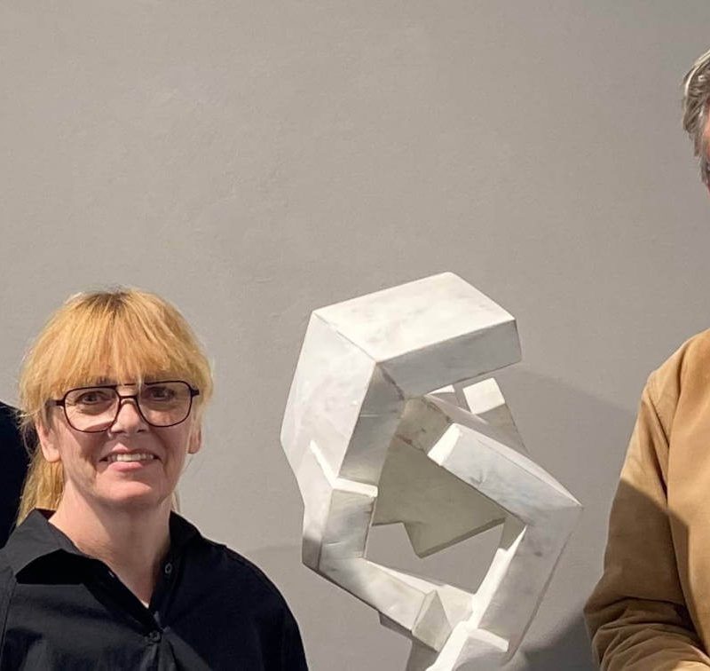 Steffi und Gordon Rieck mit Mathias Kadolph bei einem Künstlergespräch in der Galerie RIECK neben einer modernen abstrakten, weißgefassten Skulptur aus Holz
