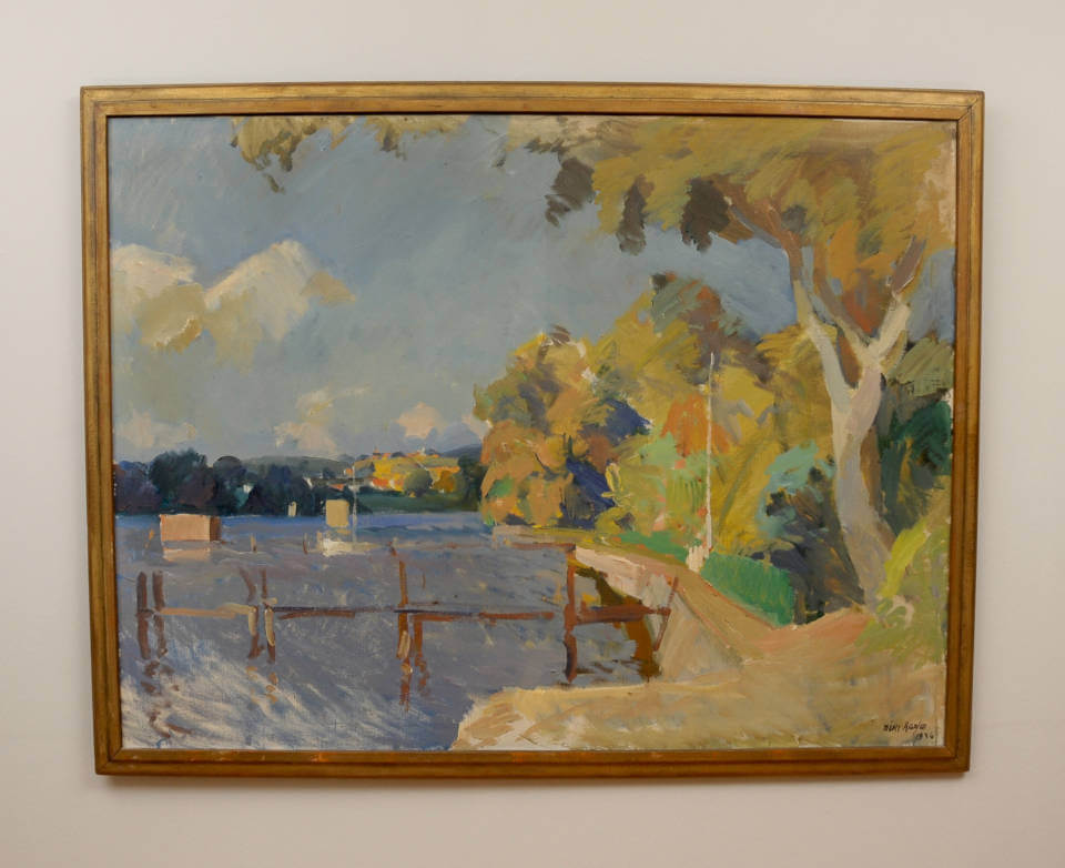„Ufer in Thurø“ von Niels Hansen: Impressionistische dänische Küstenlandschaft mit Wasser, Bootsstegen, sonnenbeschienenen Bäumen und leuchtenden Farbreflexen mit mattgoldenem Rahmen.