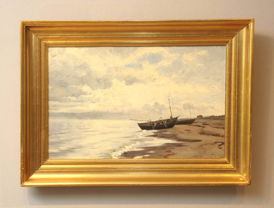 Boote am Skagener Strand von Vilhelm Groth mit Fischerbooten am Ufer, ruhiger See, bewölktem Himmel und stimmungsvoller dänischer Küstenlandschaft mit goldenem Rahmen.