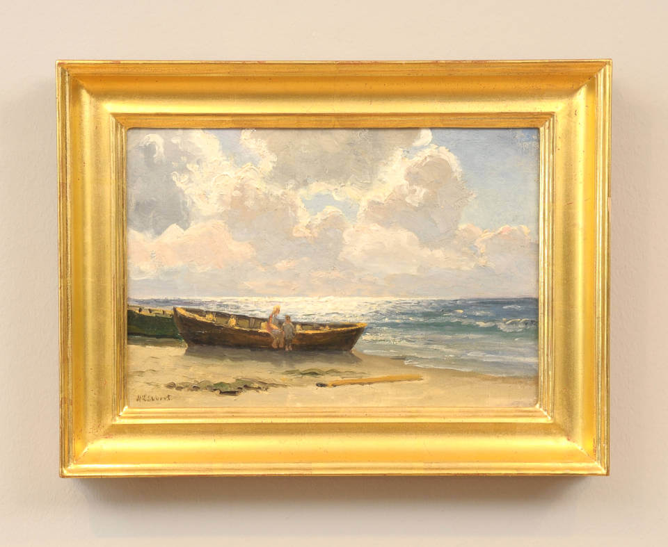 Kinder am Strand von Holger Lübbers mit zwei Figuren an einem Fischerboot am Meeresufer, unter dramatischem Wolkenhimmel und hellem Küstenlicht mit goldenem Rahmen.